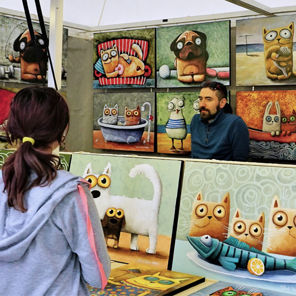 A close-up of an art dealer selling artwork to a visiting client at his shop.